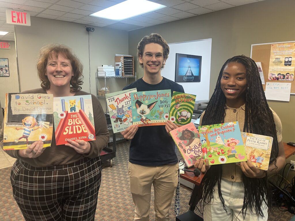 PCSI staff members display some of the donated books available.