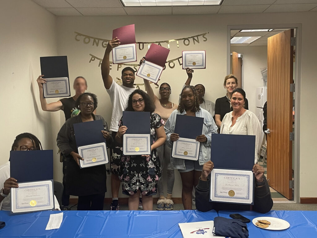 Pr.E.P. School graduates posing for a group folder, holding their diplomas.